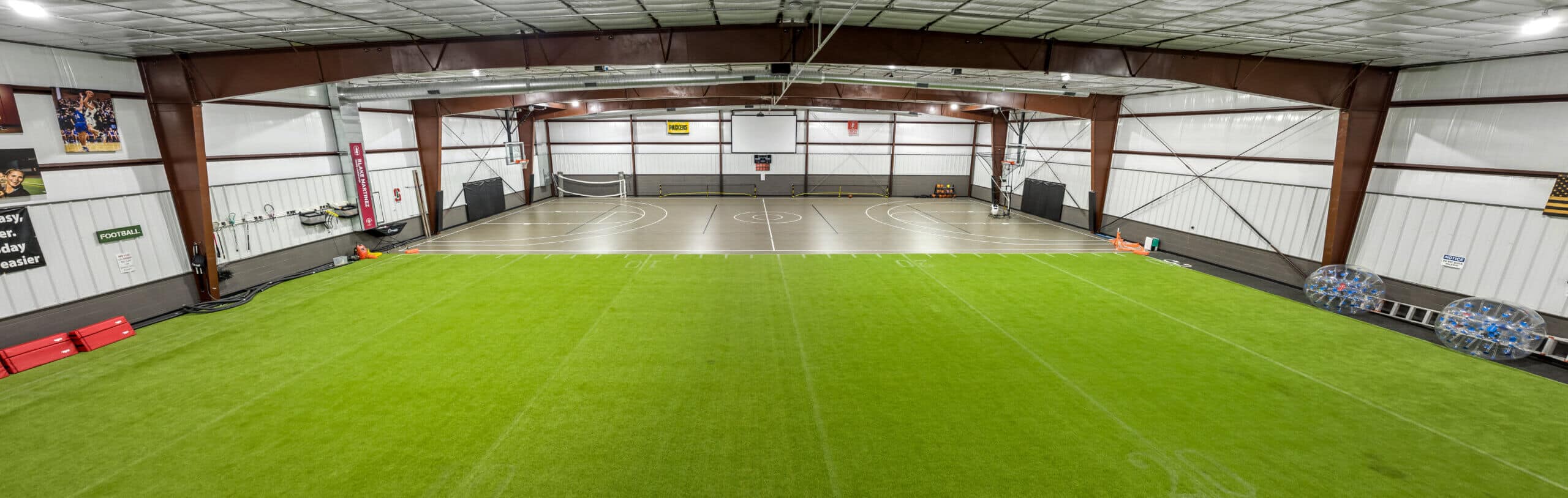 Indoor sports facility with turf and basketball court - Madan Builders Barndominium Tucson, AZ